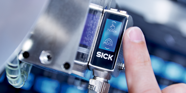 Un hombre y una mujer caminan por un almacén en el que circulan robots móviles